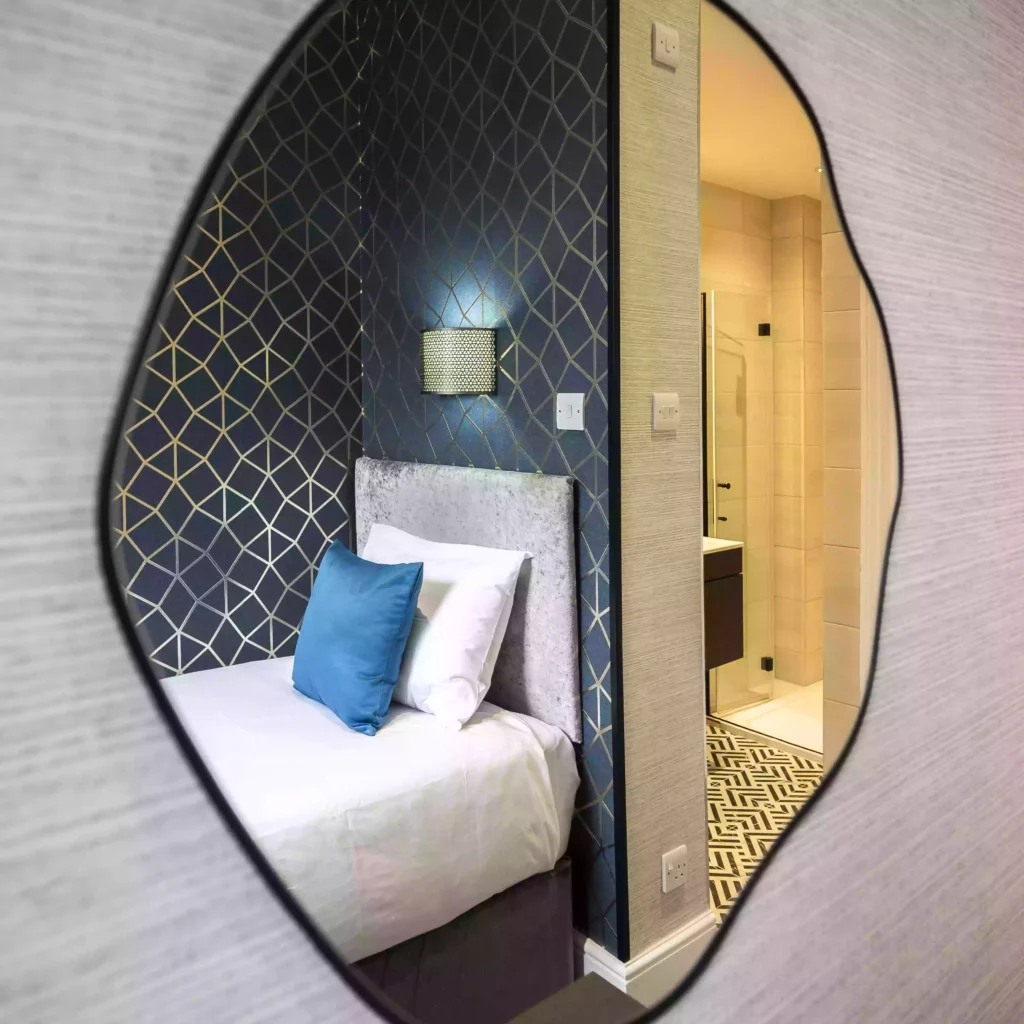 Reflection of a Single En-Suite Room at the Mentone Hotel captured in a mirror