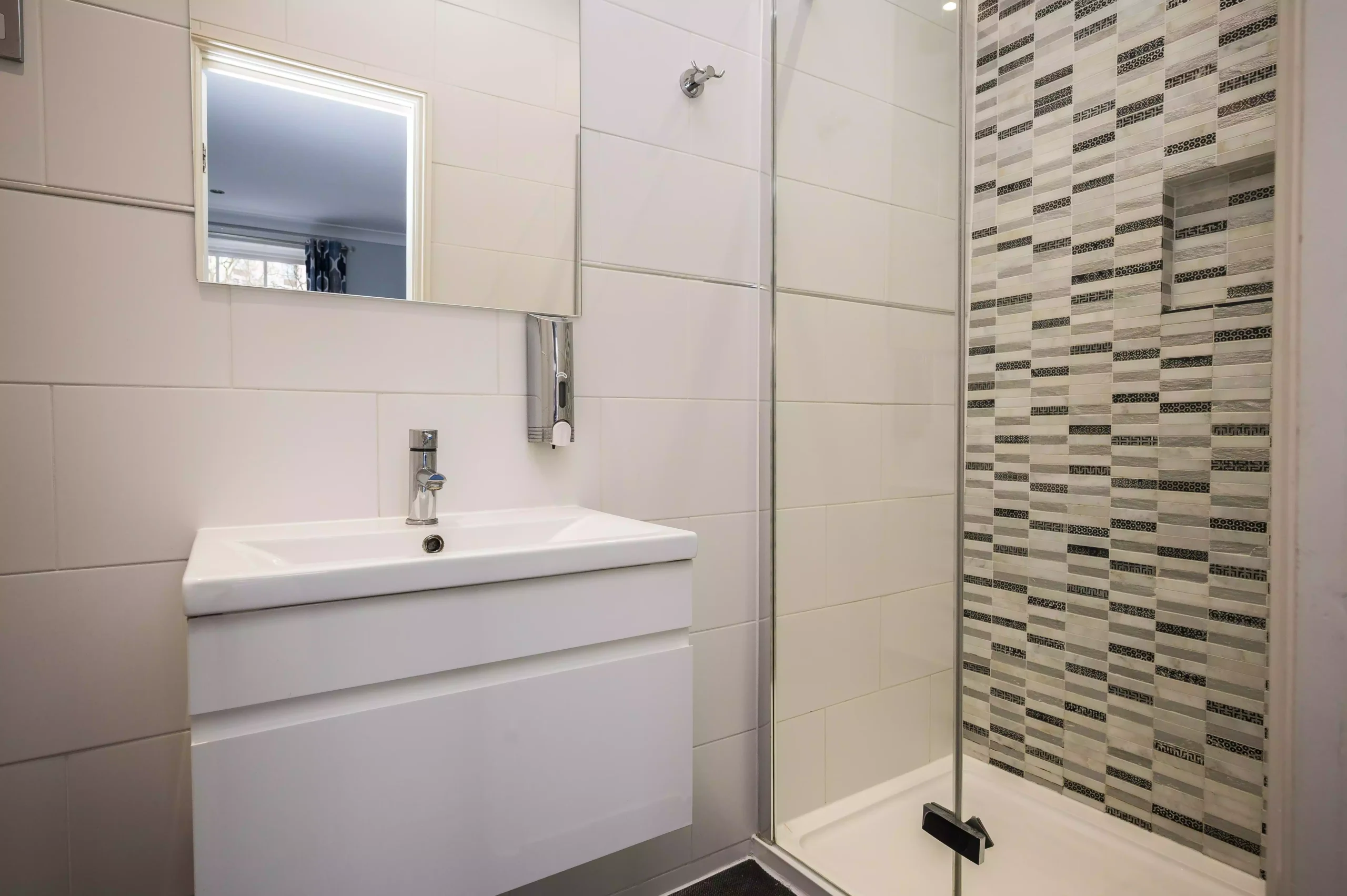 Bathroom at the Mentone Hotel with a sink and a glass-enclosed shower
