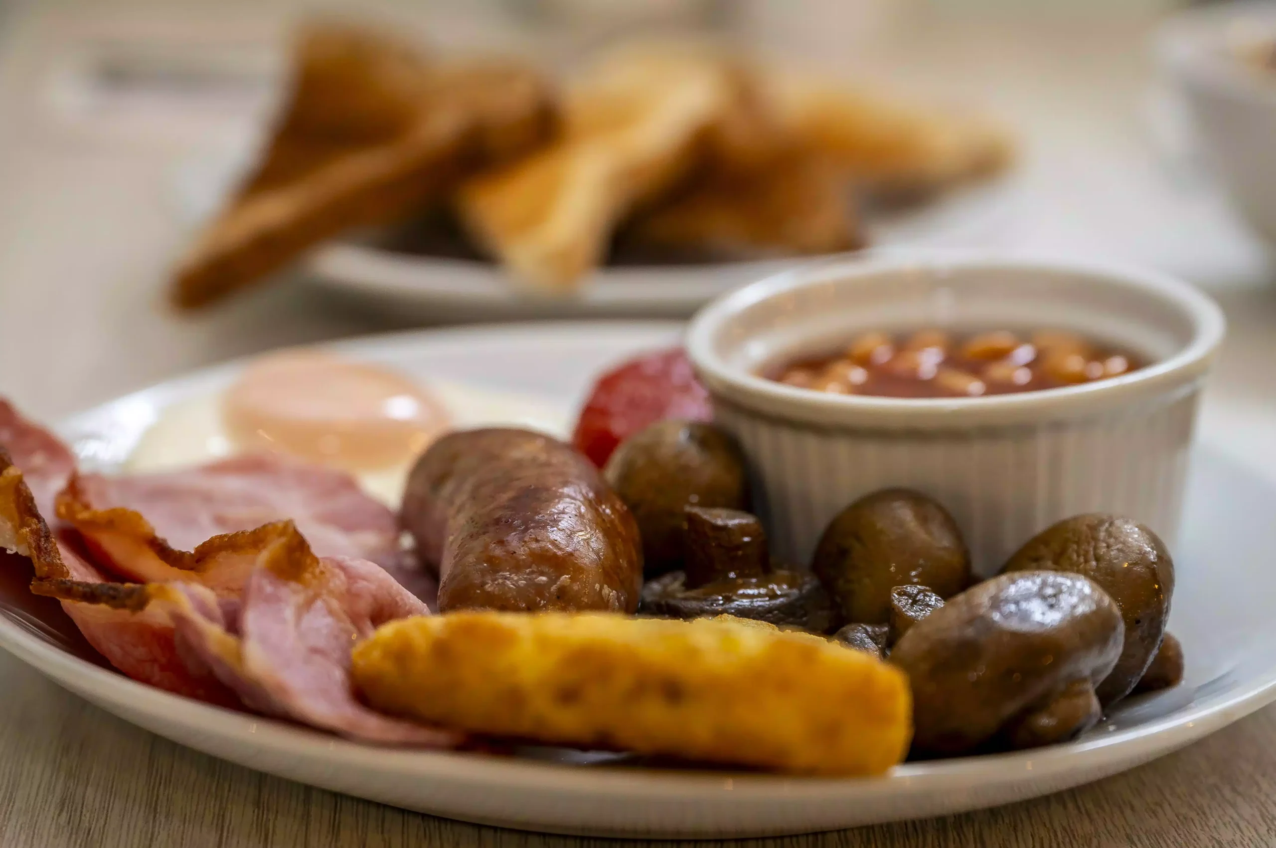 Full English breakfast with bacon, sausage, egg, and baked beans at Mentone Hotel