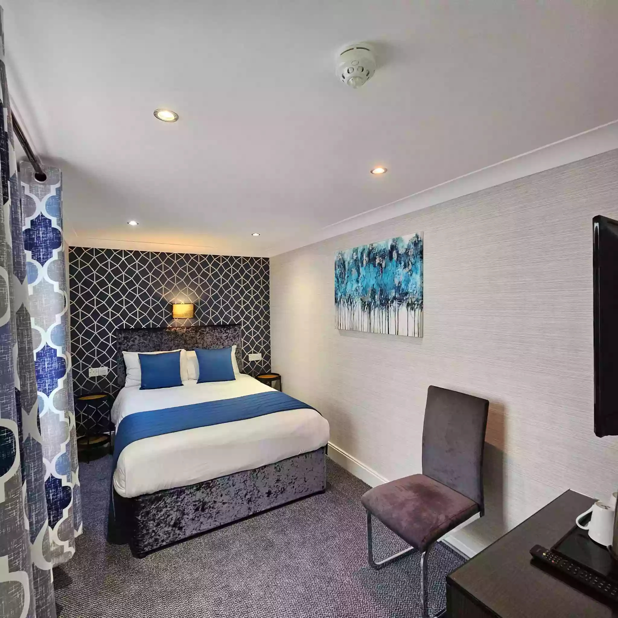 Mentone Hotel room with a double bed, TV, and desk