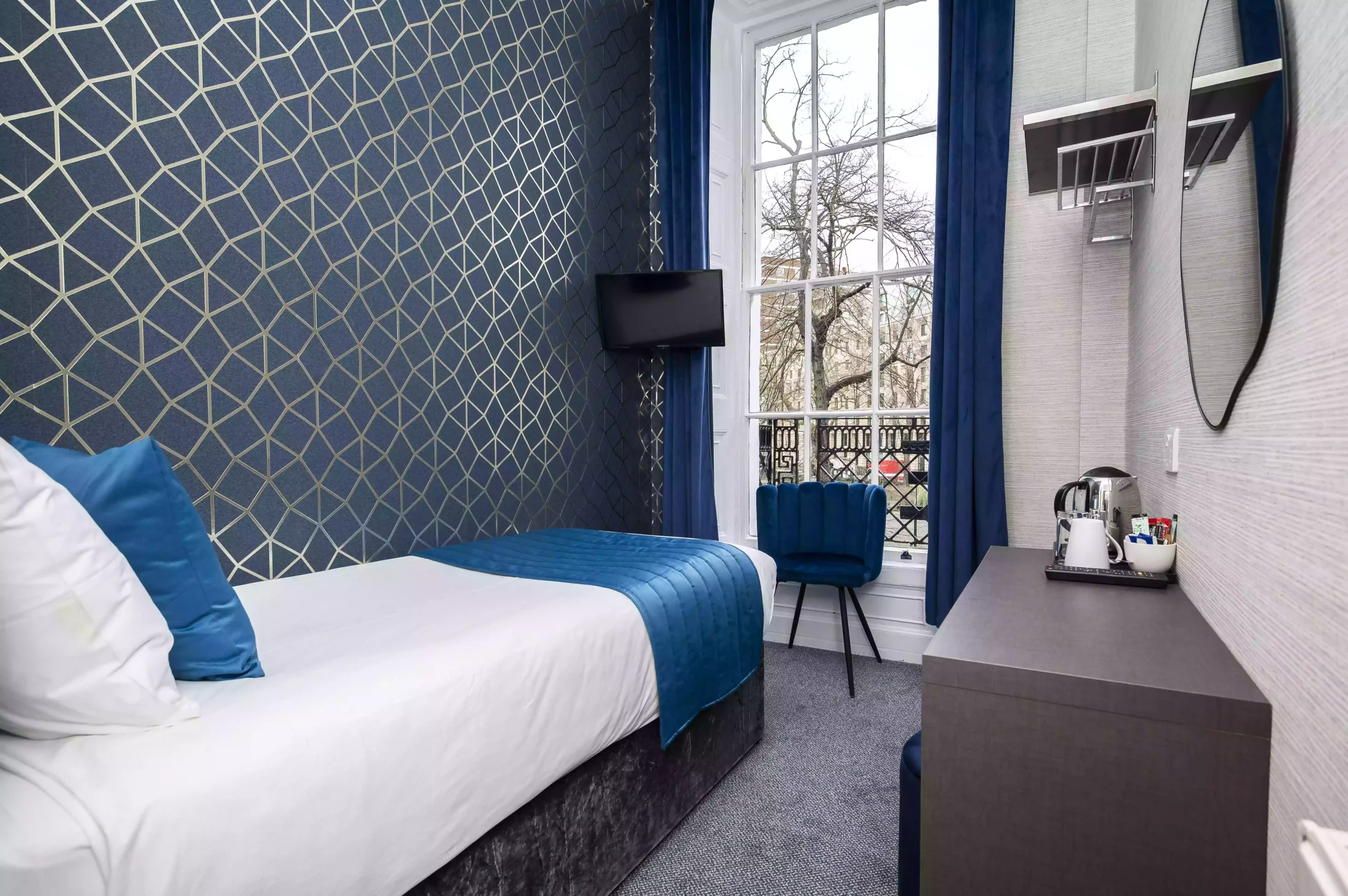 Mentone Hotel room featuring a single bed and a large window