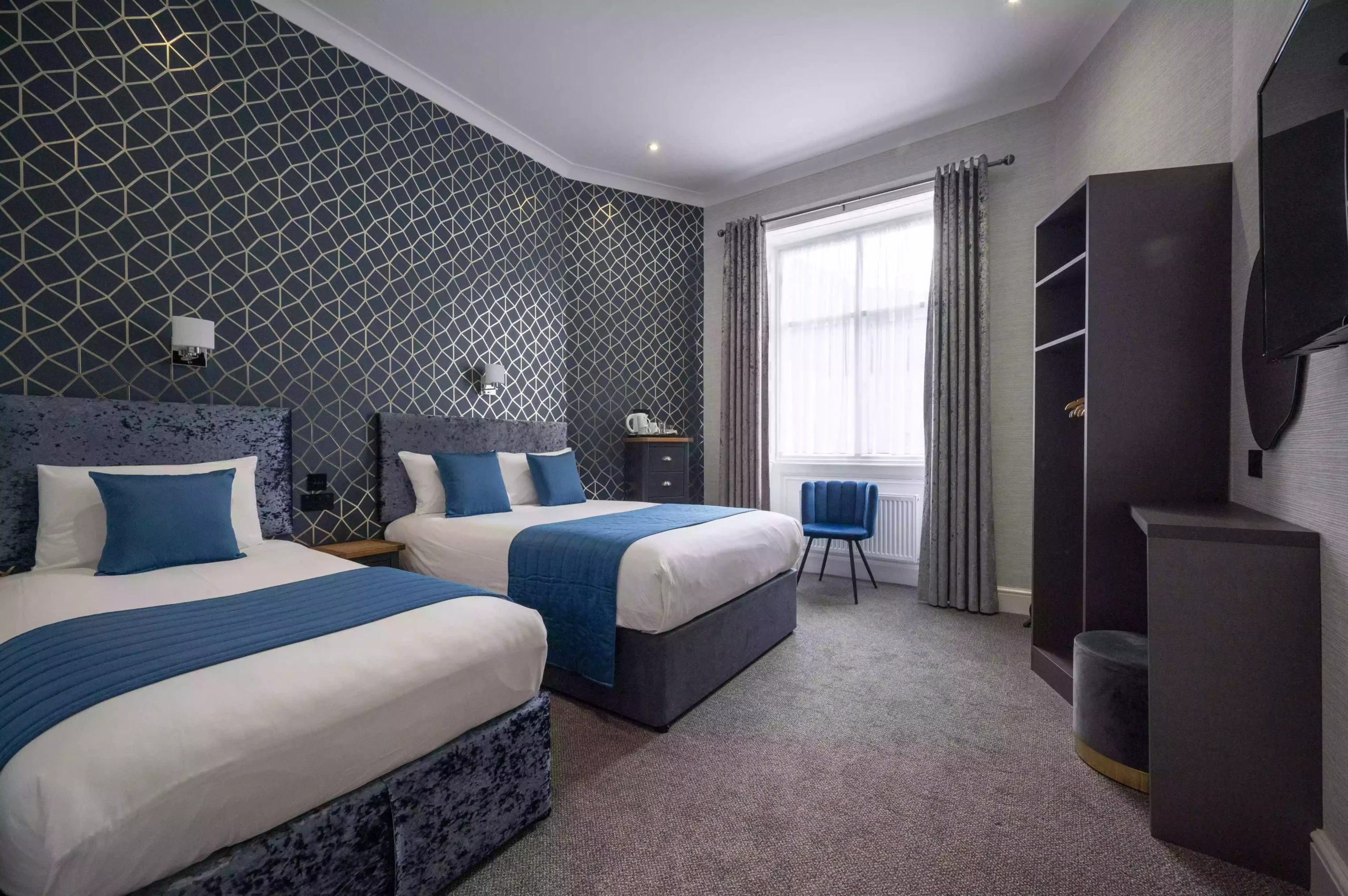 Triple en-suite room at The Mentone Hotel with two beds, an electric kettle, flat-screen TV, and additional amenities